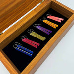 Six pairs of color weave bar earrings laying in a jewelry box by ColorUpLife.