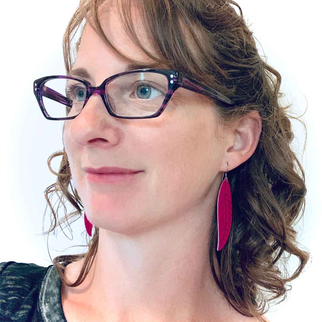 Girl wearing a pair of long magenta pink leaf earrings by ColorUpLife.