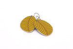 A pair of small leaf earrings in mustard yellow by ColorUpLife.