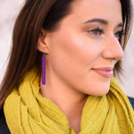 Woman wearing purple and orange color weave bar earrings by ColorUpLife.