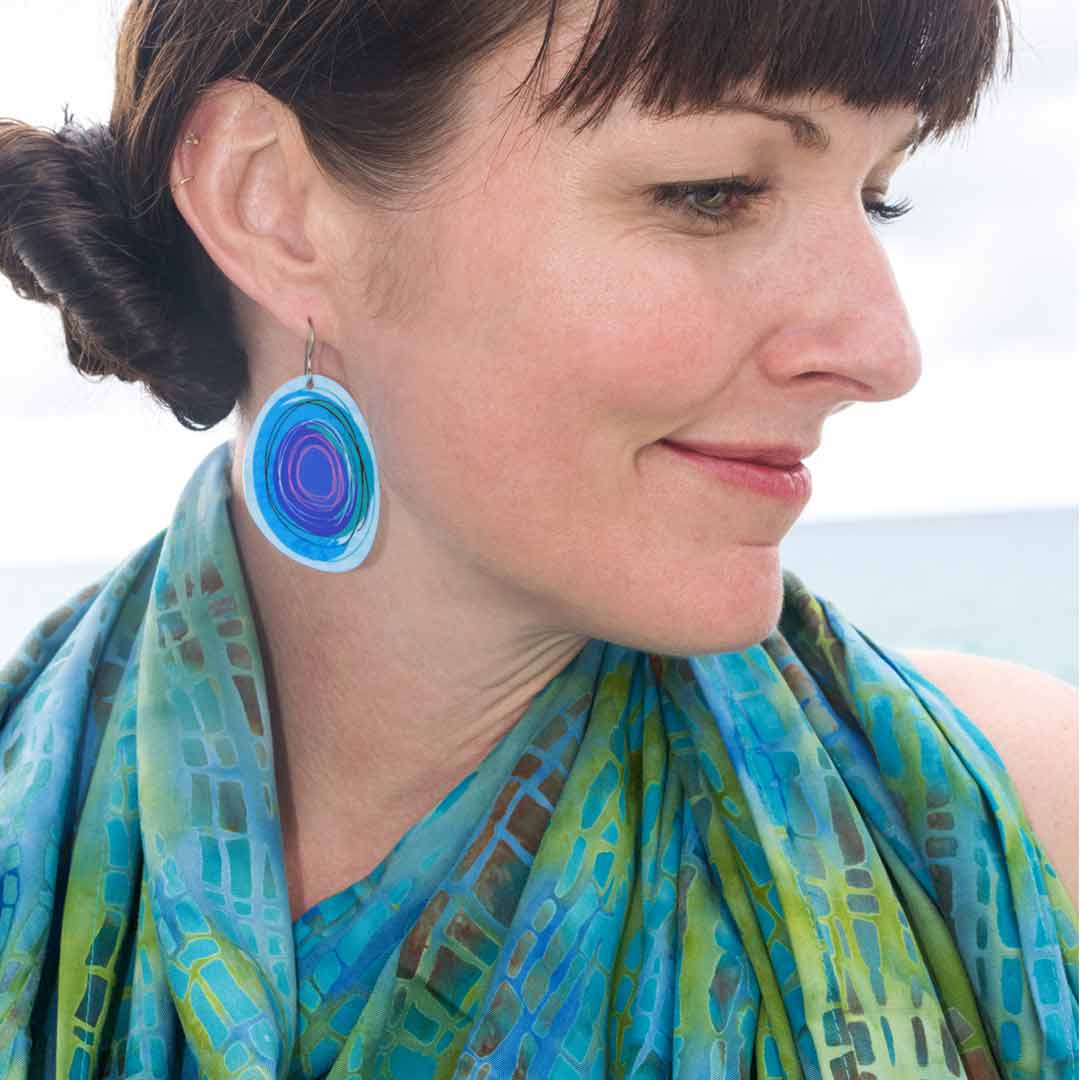 Woman wearing light blue, large solid hoop earrings by ColorUpLife.