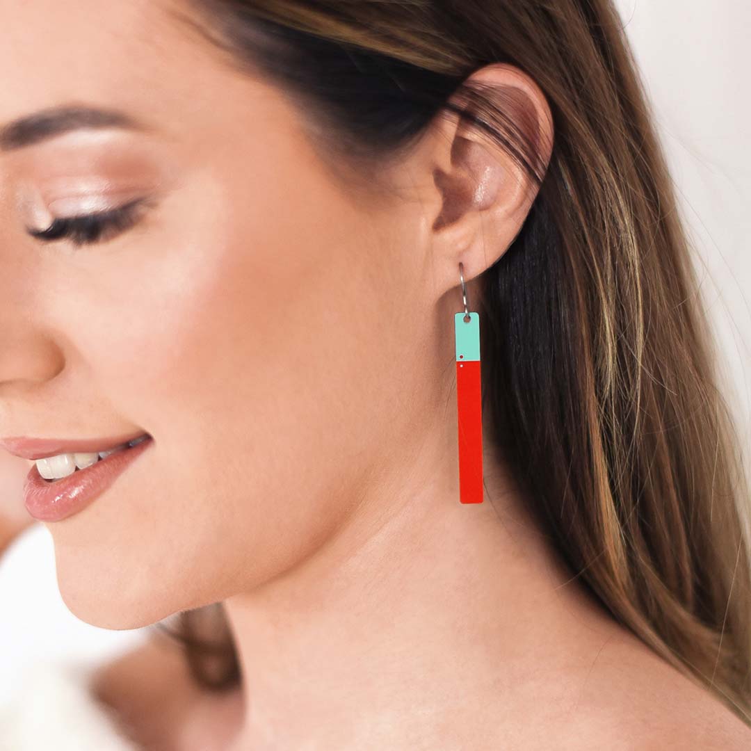 Woman wearing red and teal opposite bar earrings by ColorUpLife.