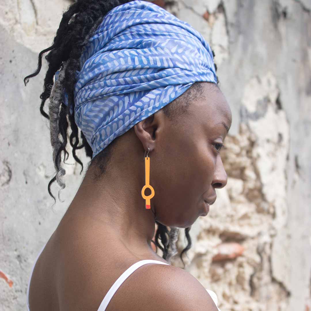 Woman wearing long asymmetrical earrings in pink by ColorUpLife.