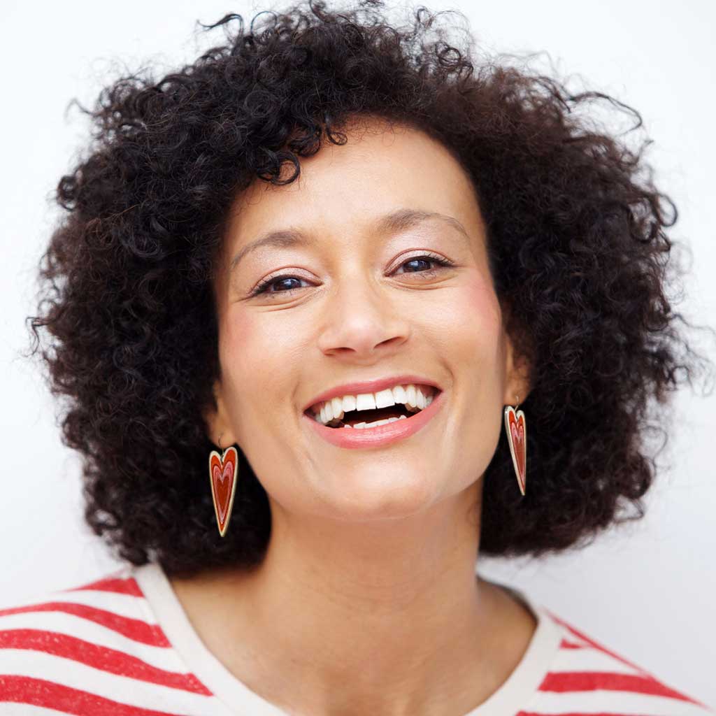 A woman wearing a pair of red and white heart dangle earrings by ColorUpLife.